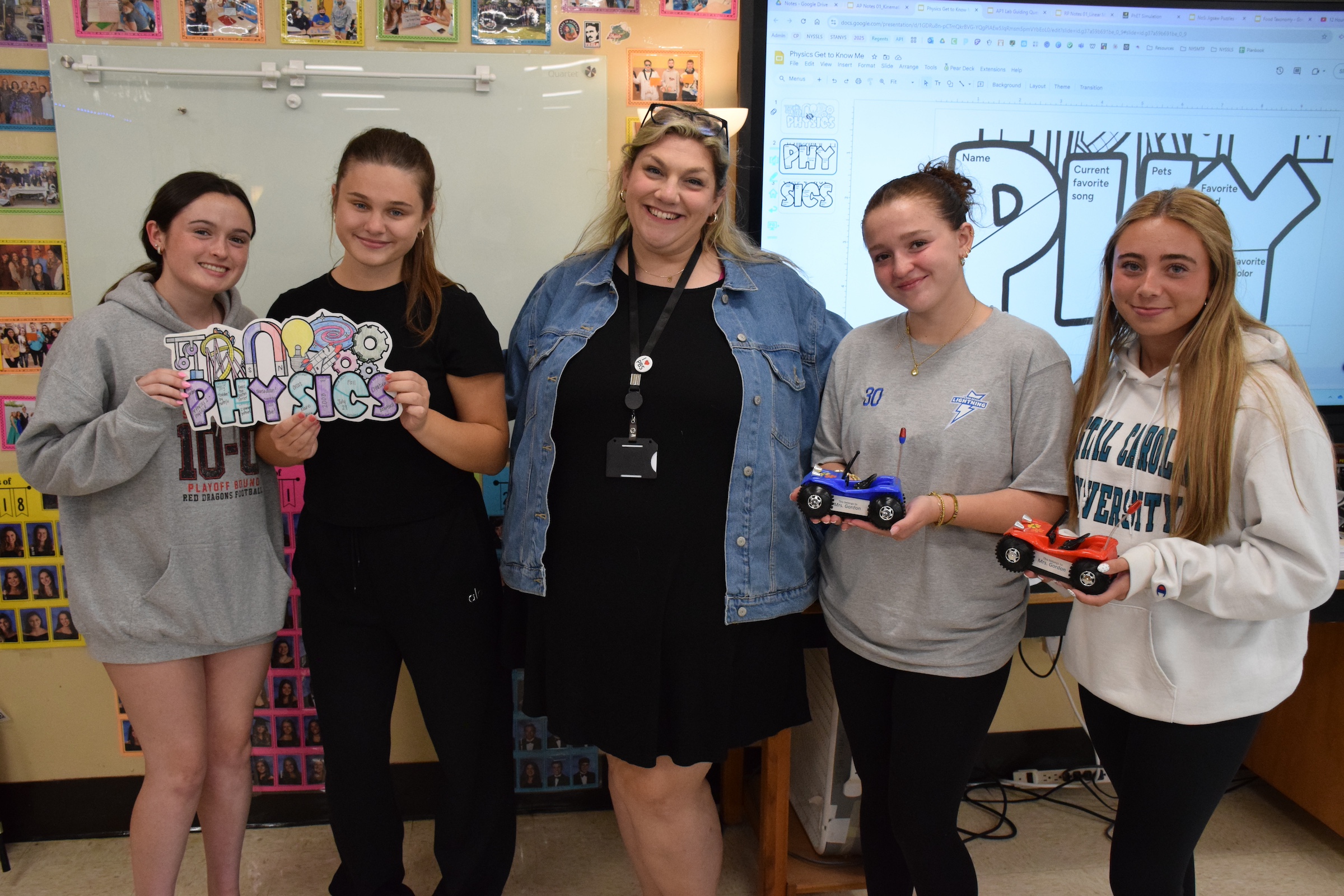 physics teacher poses with students